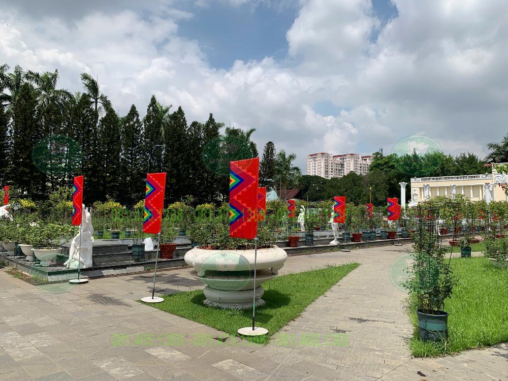Cờ chữ nhật trang trí khuôn viên ngoài trời với lối đi và cây xanh