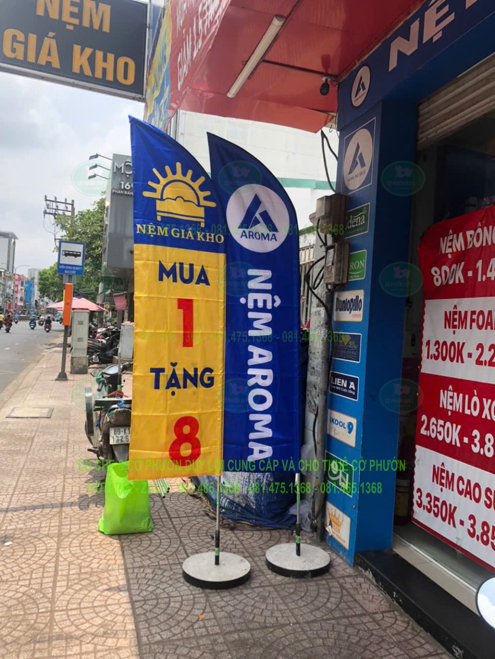 Cờ Nệm Aroma và cờ chương trình đặt cạnh mặt tiền cửa hàng nệm