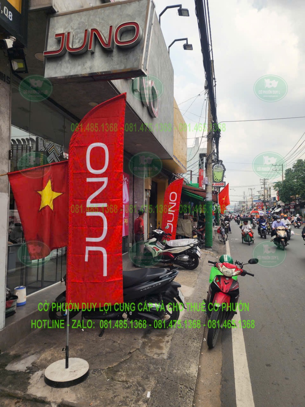Cờ cánh buồm JUNO đặt dưới biển hiệu cửa hàng và bên cờ Tổ quốc