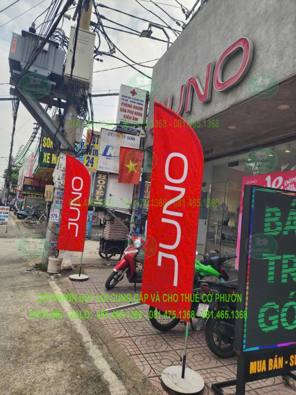 Cờ phướn JUNO đặt trước cửa hàng với đế tròn màu sáng