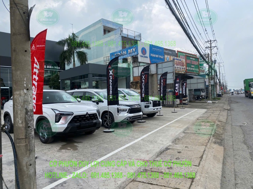 Các bộ cờ cánh buồm trên đế tròn cạnh xe Mitsubishi trưng bày
