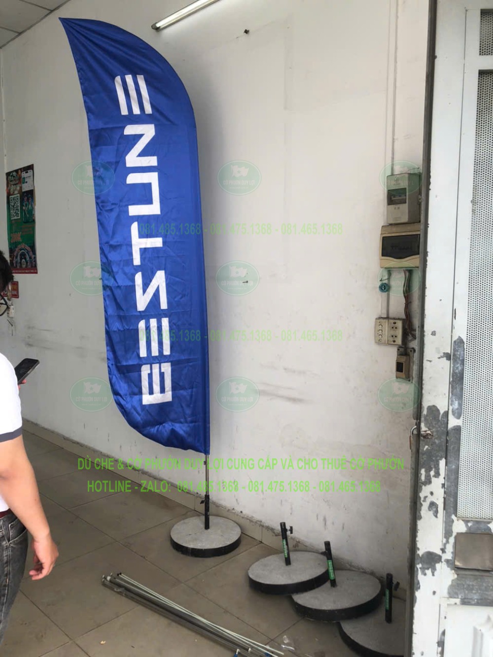 Cờ xanh chữ trắng bên các đế tròn và đoạn khung rời trong nhà